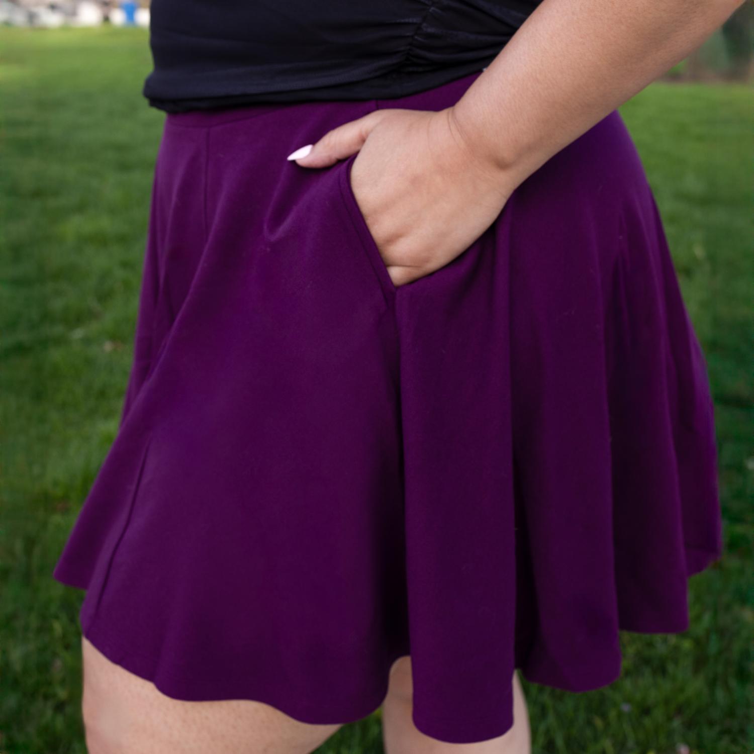 Person wearing a purple skirt with a blurred green background